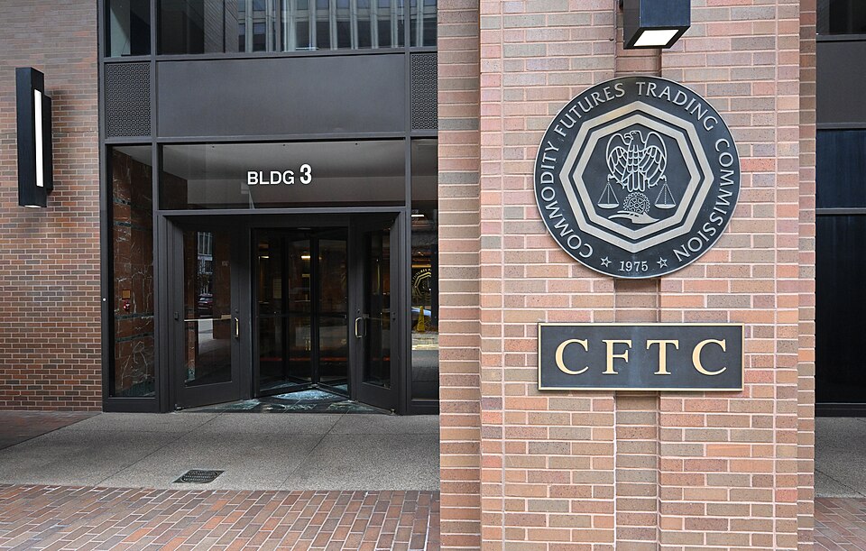 The entrance to the Commodity Futures Trading Commission at Three Lafayette Centre, 1155 21st Street NW, Washington: a brick pillar carrying the agency's round seal and a plaque reading CFTC, beside g