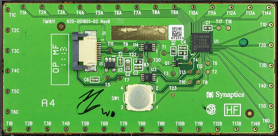 The circuit board side of a Synaptics touchpad from a ThinkPad X230 laptop, with a chip marked Synaptics T1320A at the upper right and the Synaptics name printed on the board