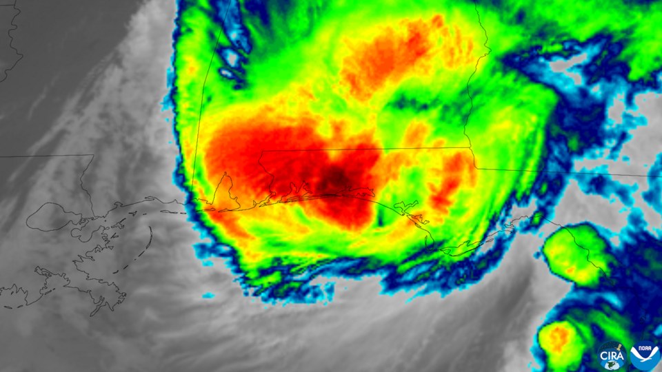 Colorized infrared satellite image of Hurricane Isaias at landfall, its coldest cloud tops in red and black over the western Florida Panhandle coast, with Louisiana and Mississippi in clear gray air t